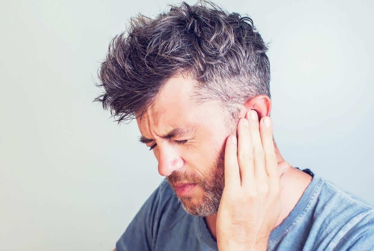 Man with earache is holding his aching ear body pain concept