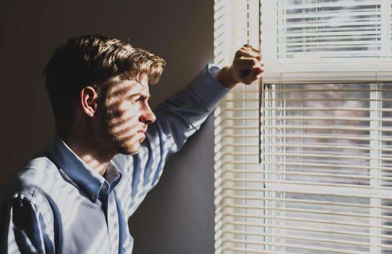 Man looks outside of window
