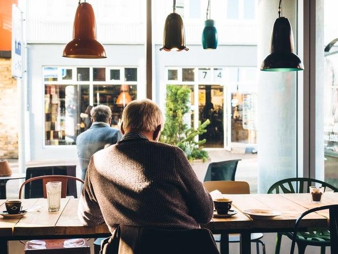 Man sits inside coffee shop.