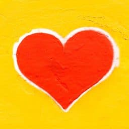 A picture of a red heart with a yellow background.
