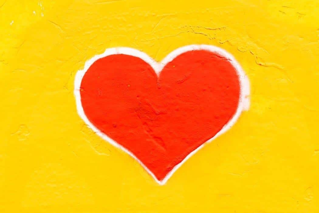 A picture of a red heart with a yellow background.