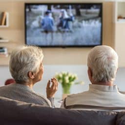 Older couple watching television together.
