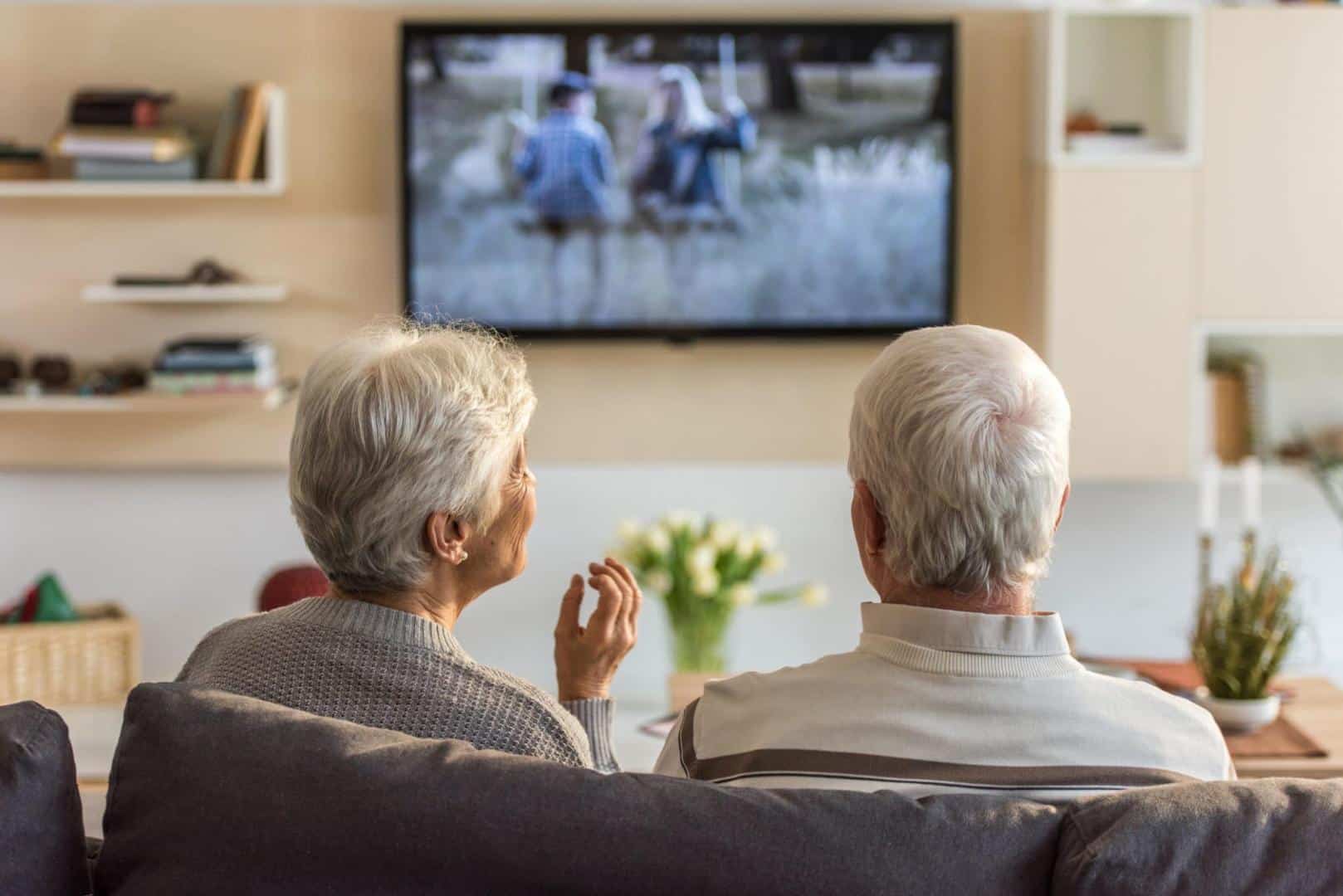 Older couple watching television together.
