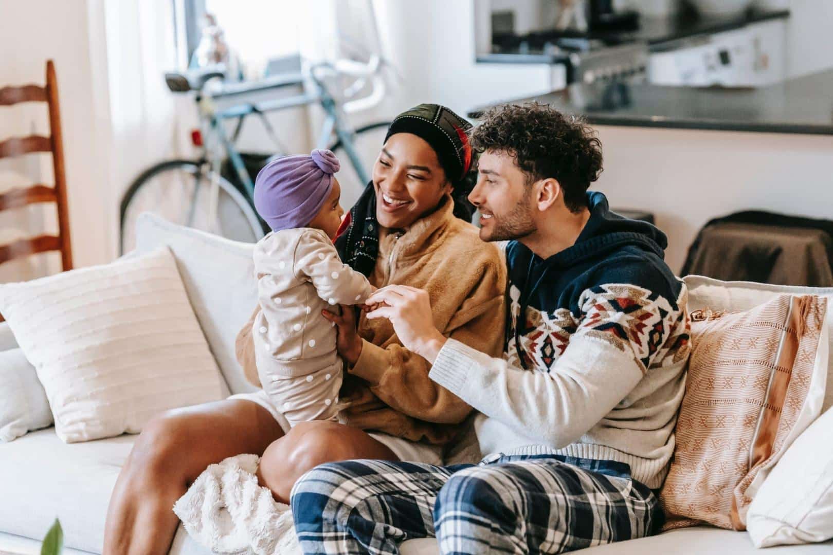 Happy family playing and talking with their baby.