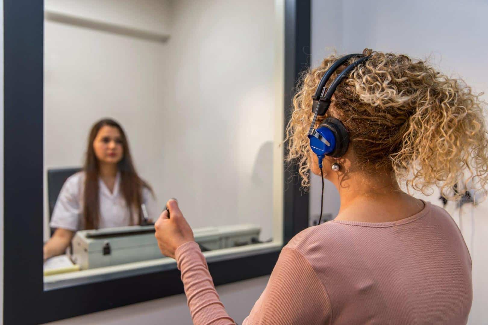 Woman gets a hearing test in an audiologist's office.