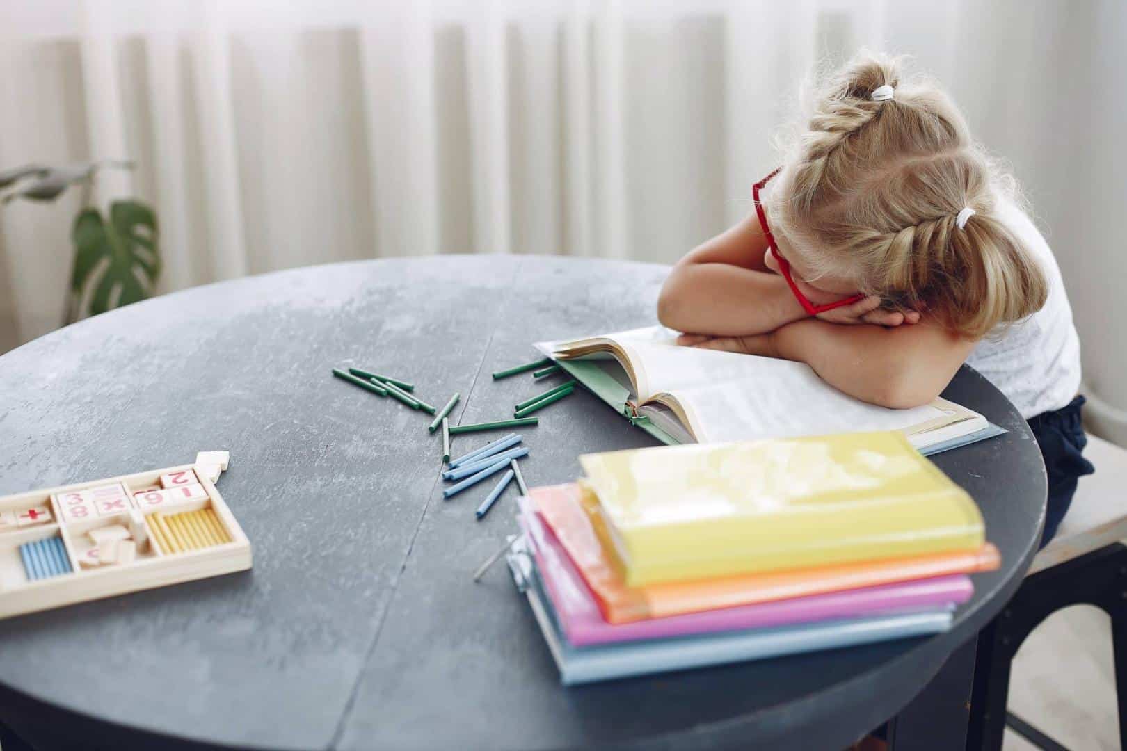 Little girl taking a nap at her desk.