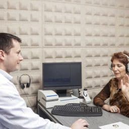 Audiologist giving a woman a hearing exam.