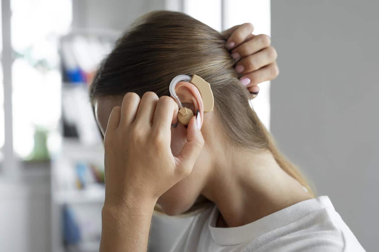 Woman adjusts hearing aids 