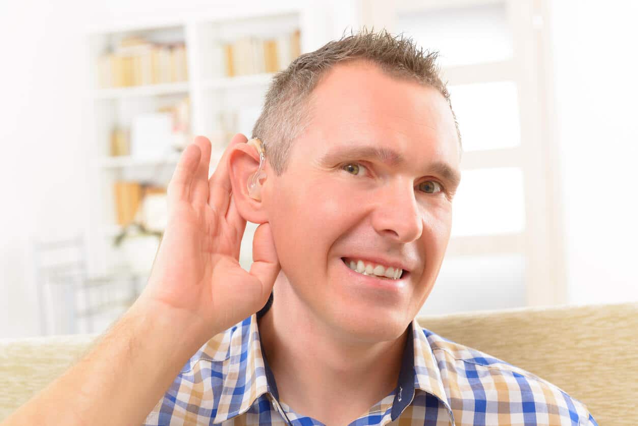 Man showing off his new hearing aid.