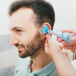 ENT specialist creating an ear mold for a patient