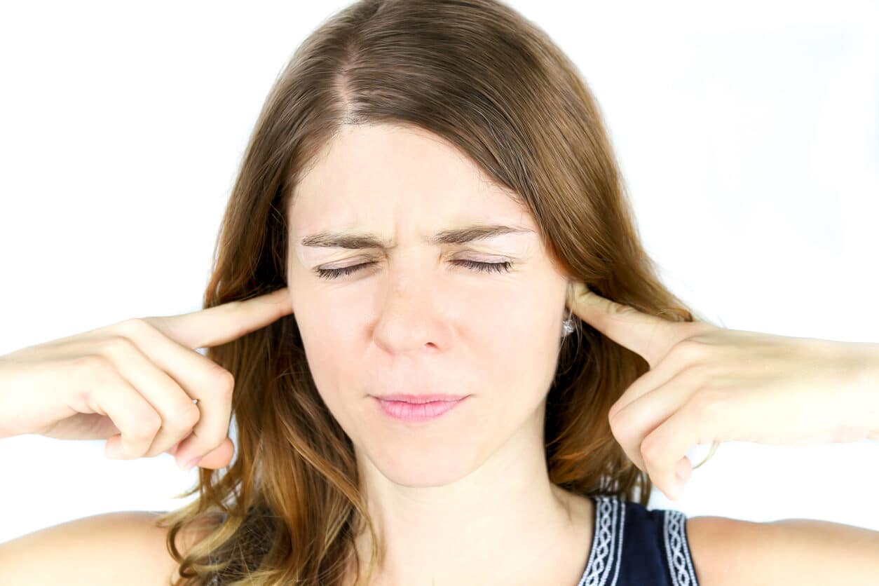 Woman plugs ears to block sounds